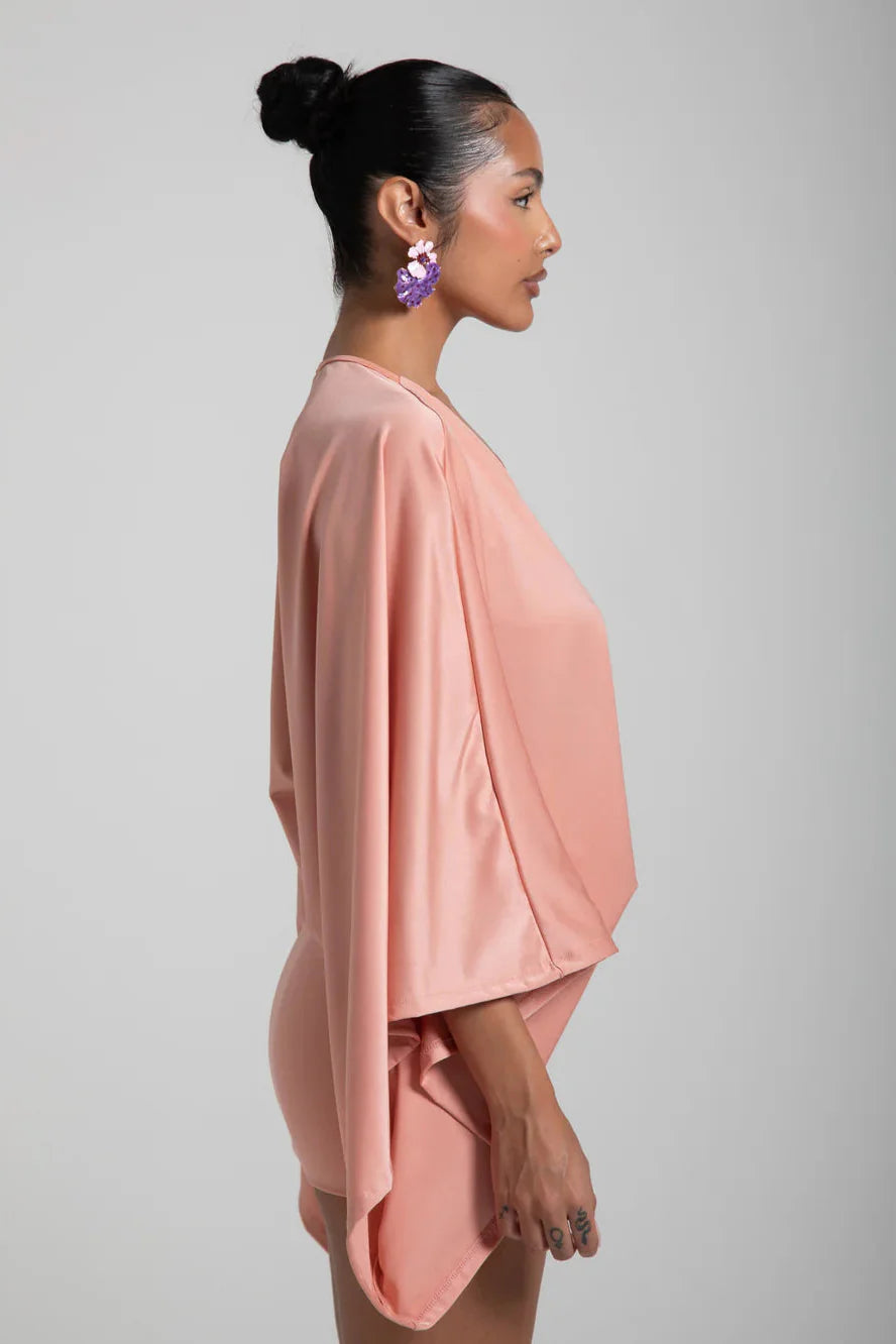 Woman wearing a pink outfit against a gray background