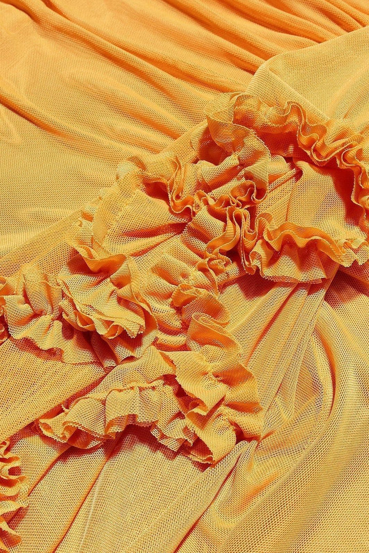 Close-up texture of yellow fabric with orange-toned ruffled trim detail
