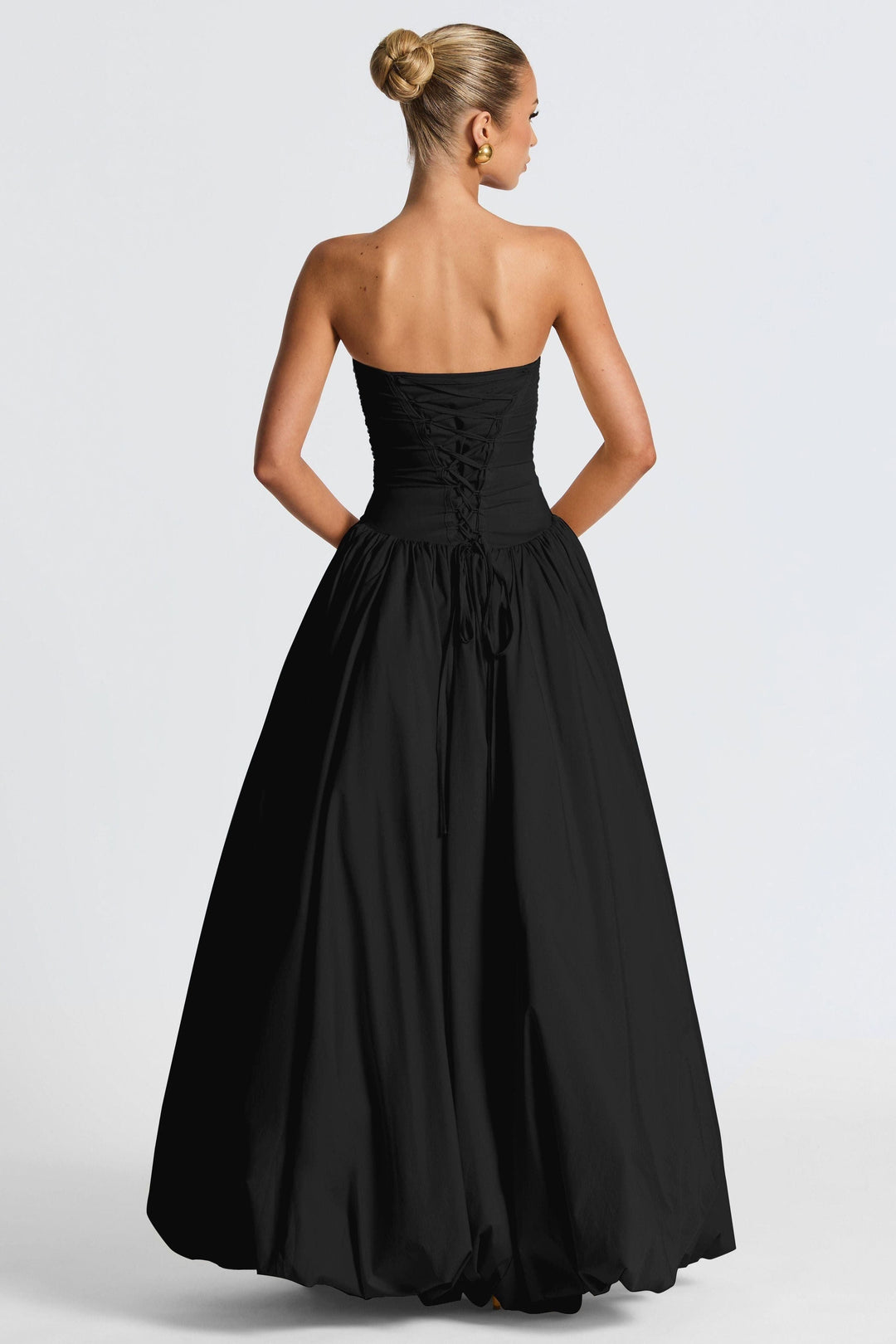 Back view of black strapless ruched maxi dress with lace-up corset back