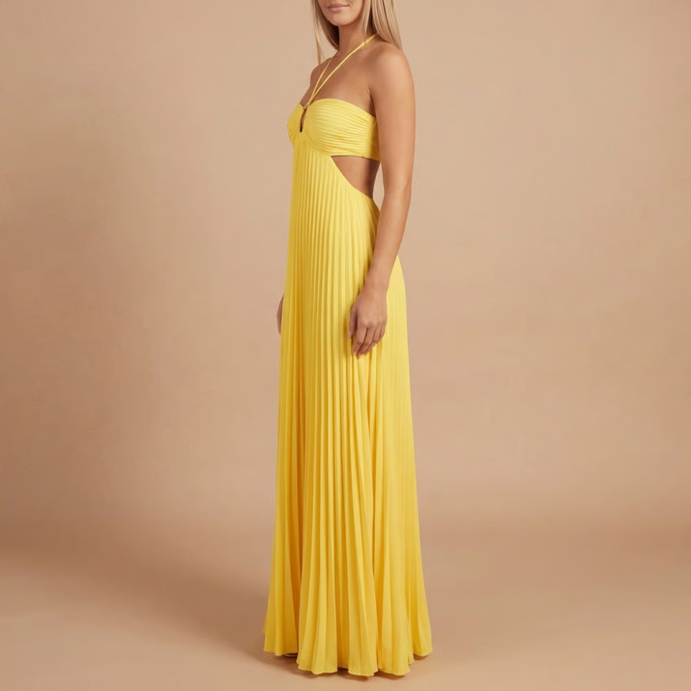 Side profile of yellow halter maxi dress with pleated skirt and cutout