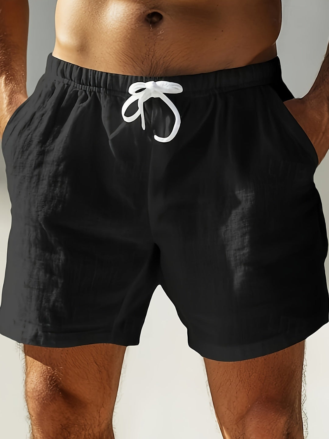 Black swim shorts with elastic waist and white drawstring, front view, men bathing suit