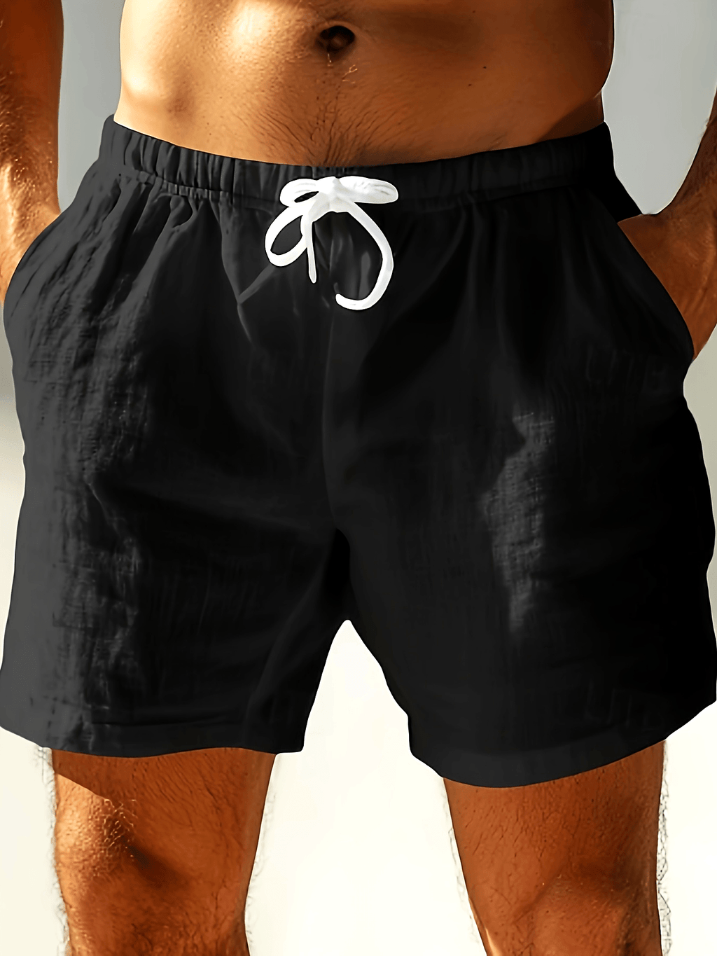 Black swim shorts with white drawstring, front view on model, relaxed fit bathing suit men