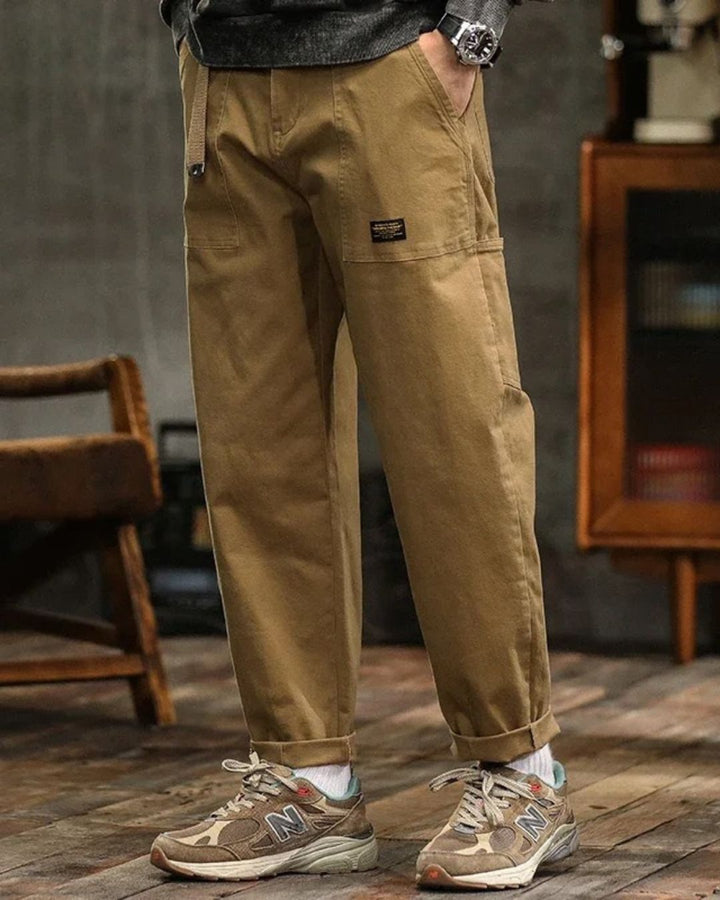 Black cargo pants with relaxed straight leg, belt strap detail, and cuffed ankles