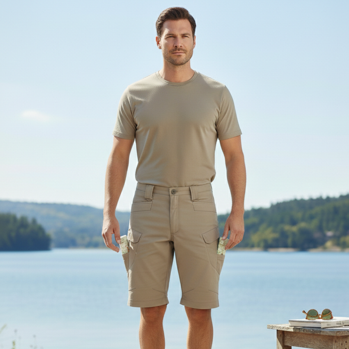 Front view of tan men cargo shorts with pockets, worn with a fitted beige t shirt by the water