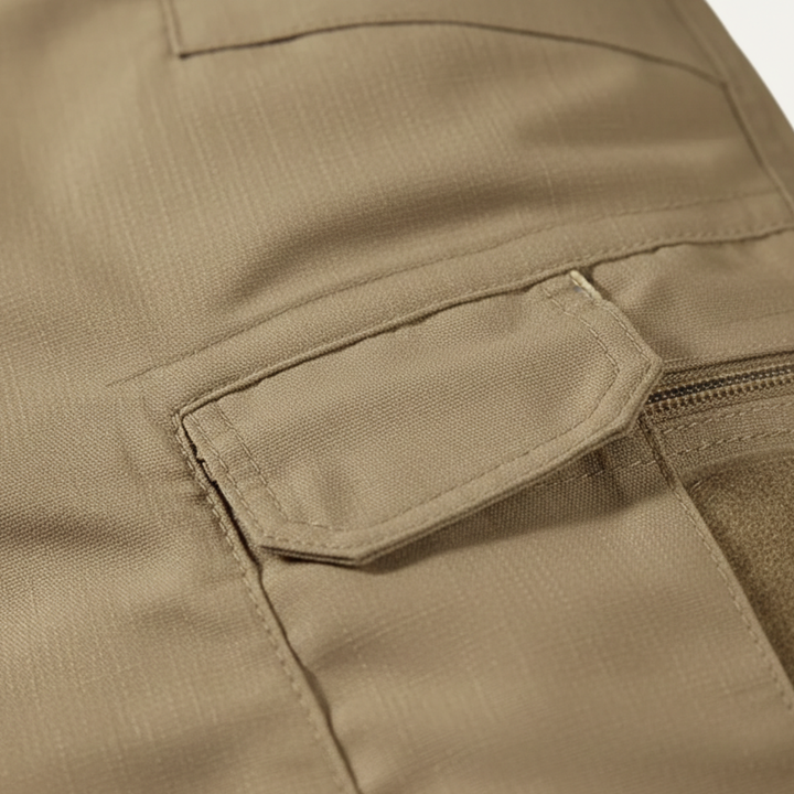 Close-up of tan cargo shorts pocket and stitched flap detail on durable cotton shorts