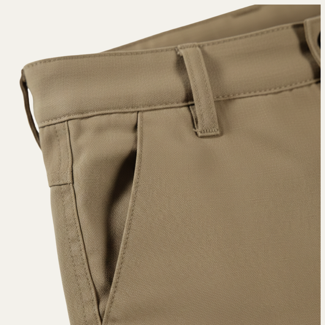 Close-up of tan men cargo shorts waistband, belt loop, and side pocket opening