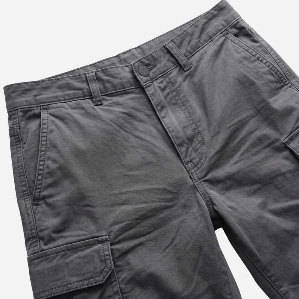 Close-up of dark gray cargo shorts waistband and front pocket details, men's shorts