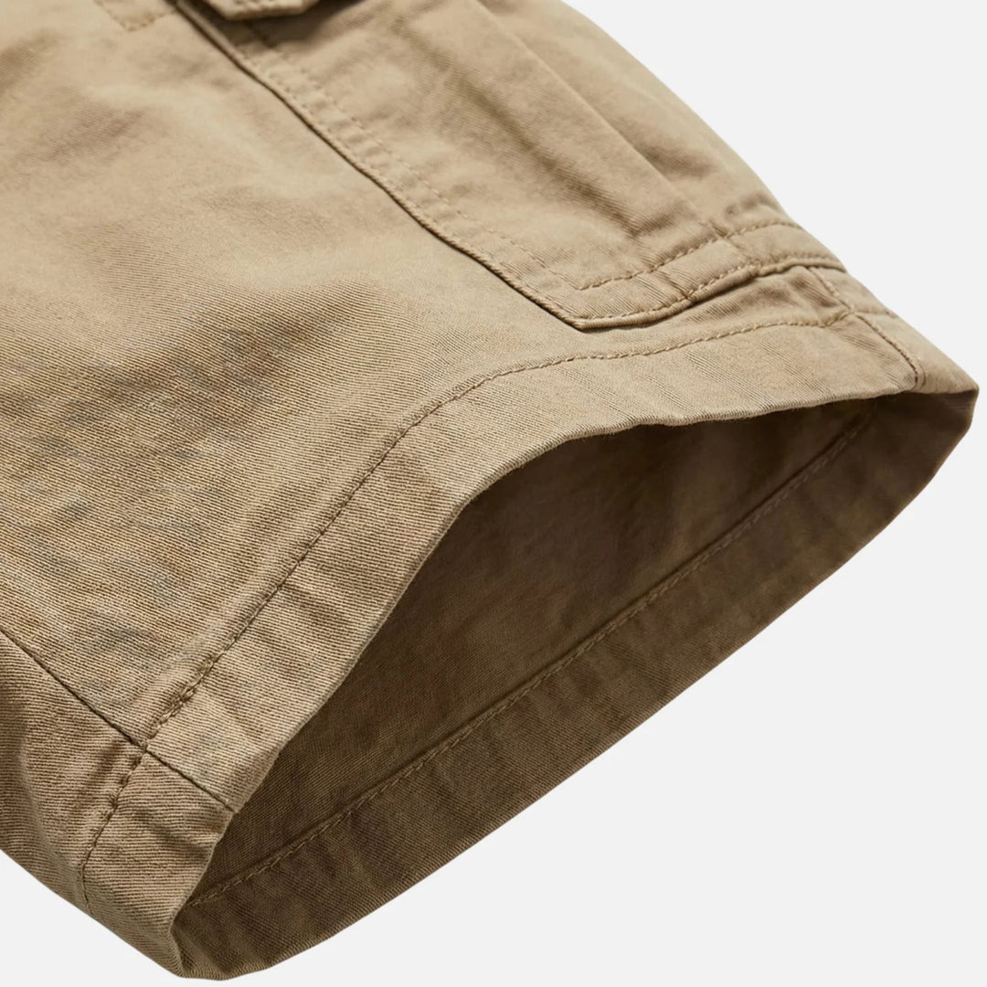 Close-up of tan cargo shorts hem and side seam stitching, durable men's shorts