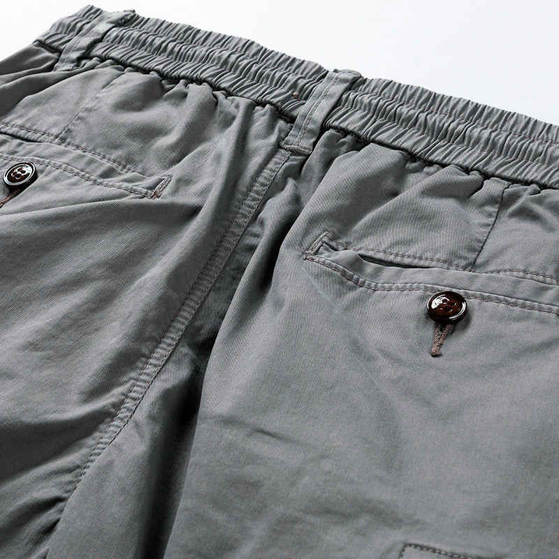 Close-up of gray cargo shorts pocket and hem, highlighting utility pocket details and stitching