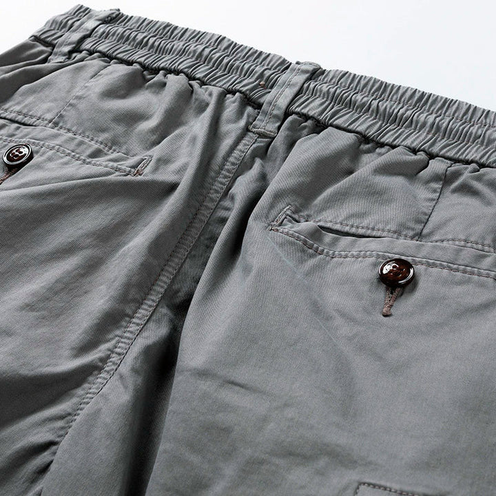Close-up of gray cargo shorts pocket and hem, highlighting utility pocket details and stitching