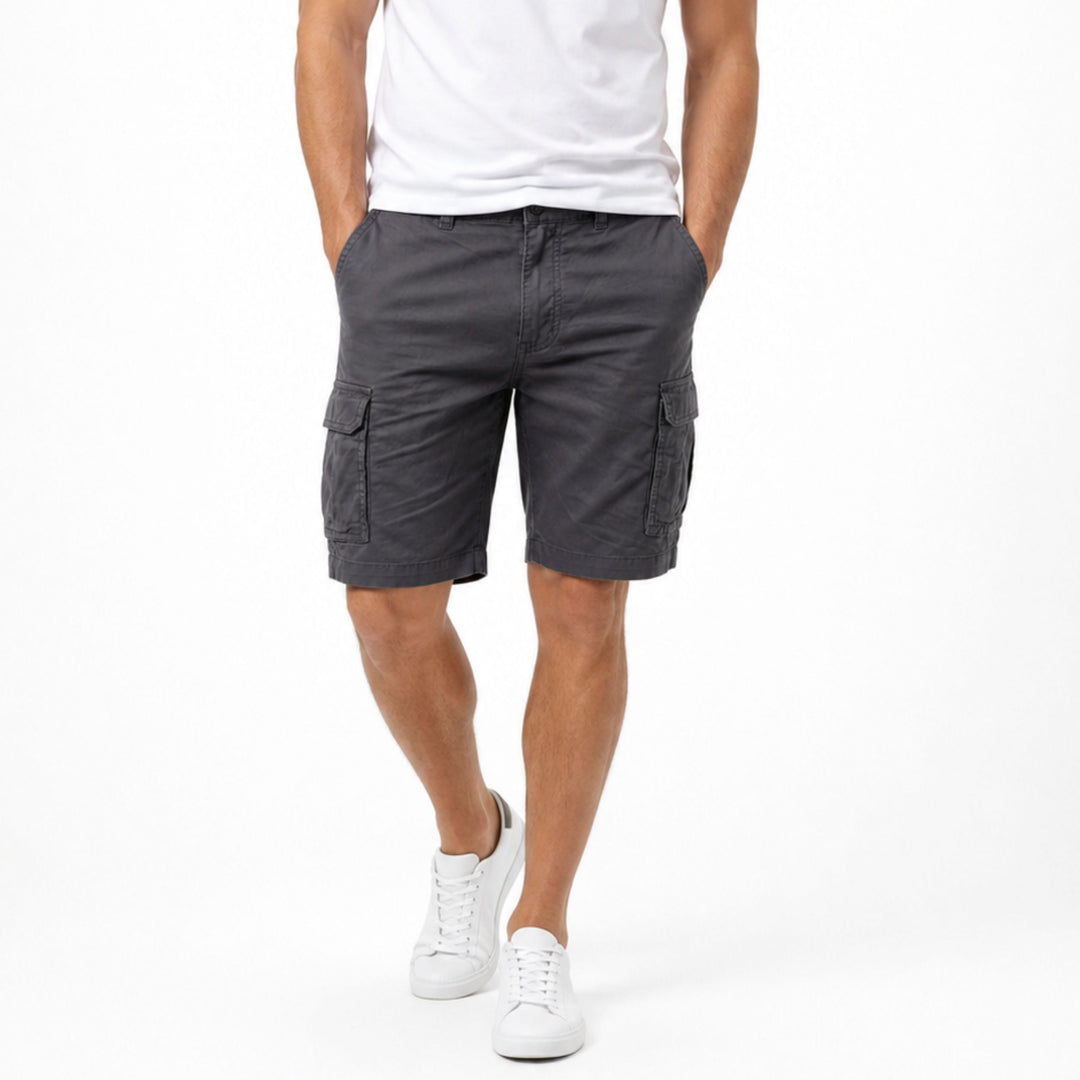 Dark gray men cargo shorts with pockets, front view on model with white sneakers
