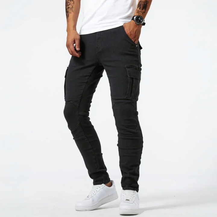 Black cargo skinny jeans with side pockets, front view on male model wearing white sneakers