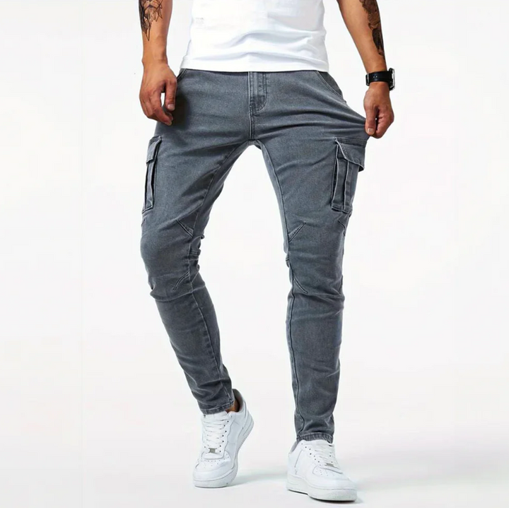 Front view of gray cargo skinny jeans with side pockets and tapered fit on male model