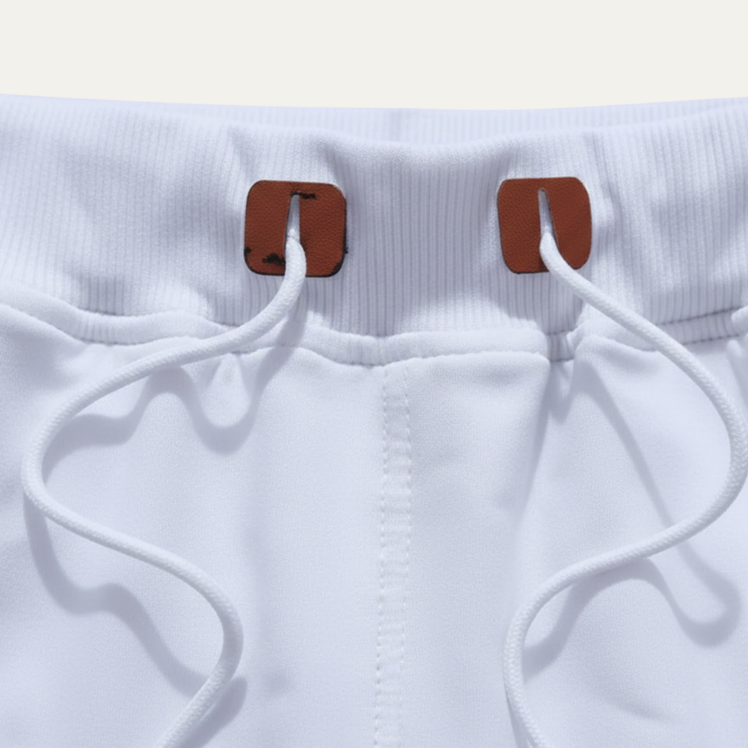 Close-up of white jogger shorts waistband with drawstring and brown tabs