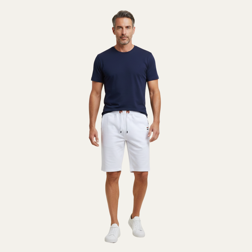 Model wearing white jogger shorts with drawstring waist and knee-length fit