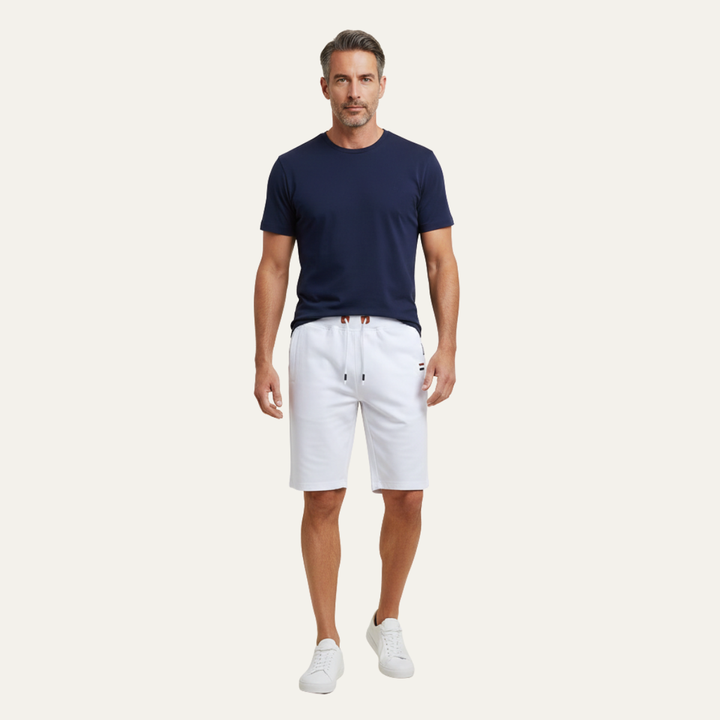 Model wearing white jogger shorts with drawstring waist and knee-length fit