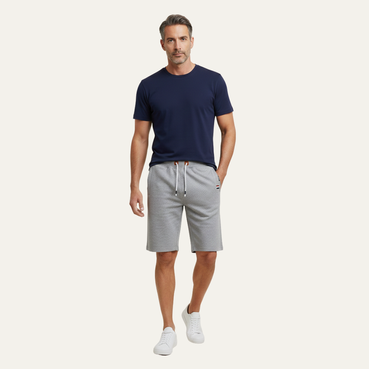 Model wearing light gray casual shorts with drawstring waist and relaxed fit