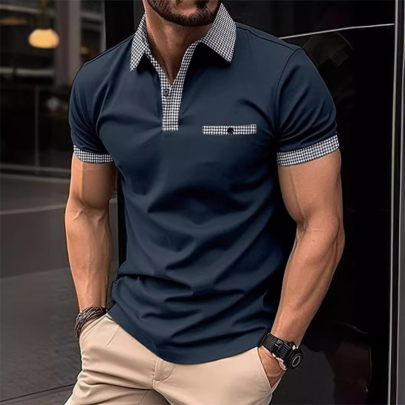 Dark navy men's polo shirt with checkered trim details worn with beige pants in an urban setting