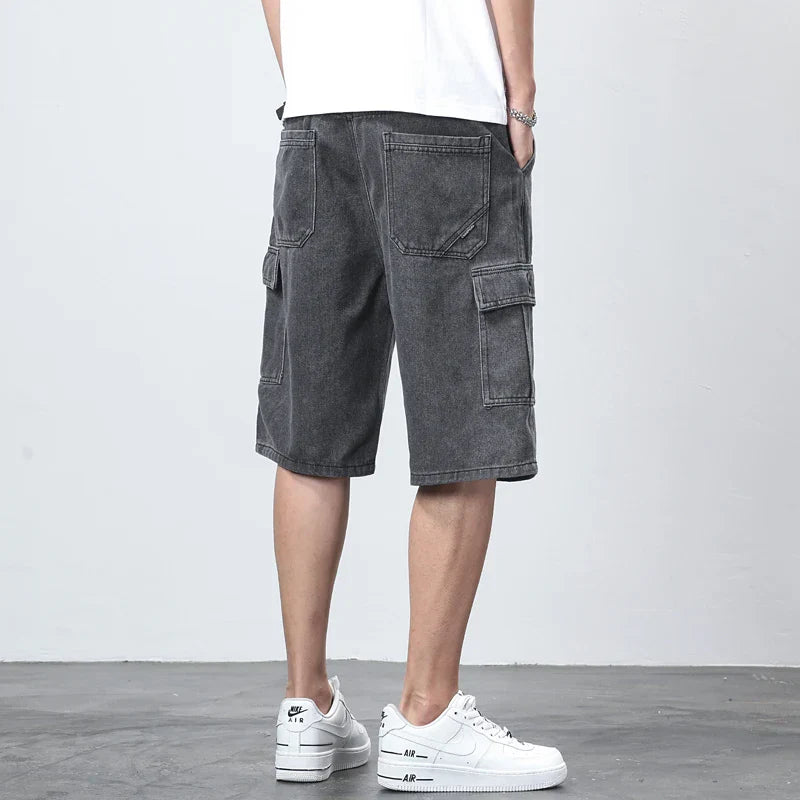 Back view of dark denim cargo shorts with knee length cut and utility pockets