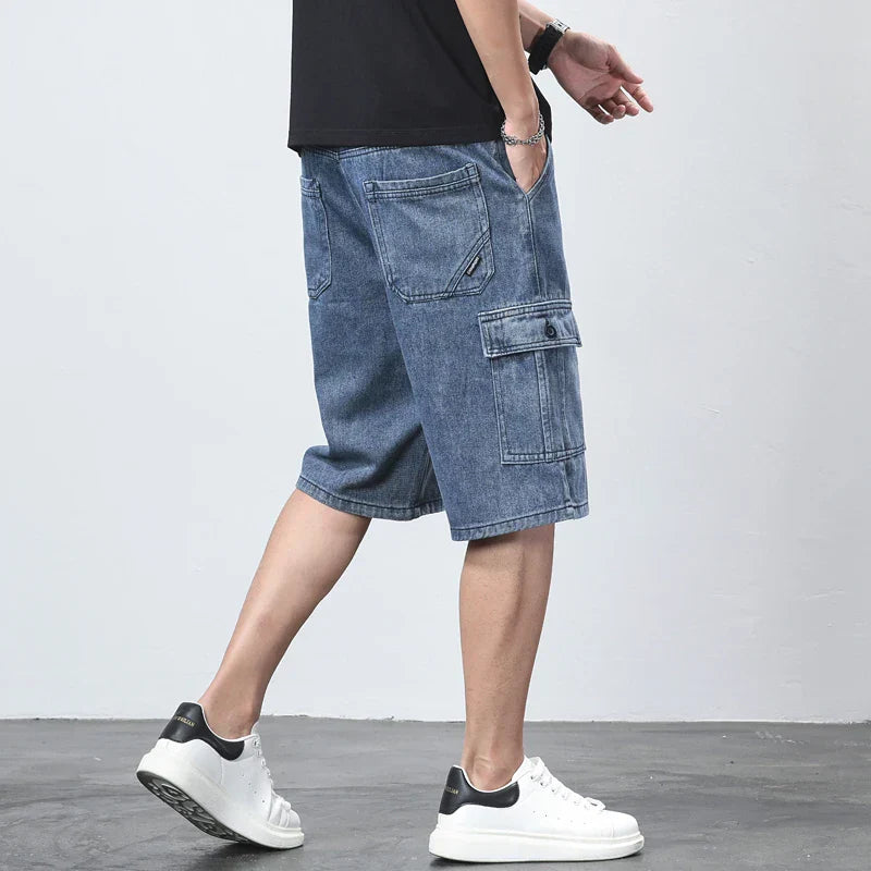 Blue denim cargo knee length shorts with side flap pocket, worn with white sneakers