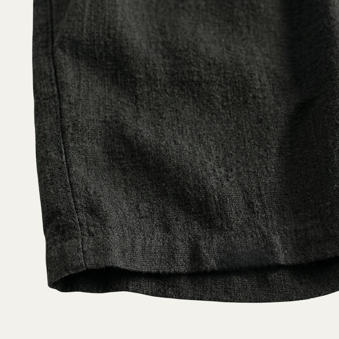 Close-up of black linen shorts hem and textured fabric, casual summer shorts