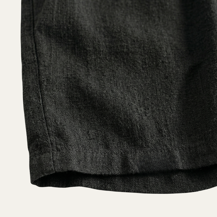 Close-up of black linen shorts hem and textured fabric, casual summer shorts