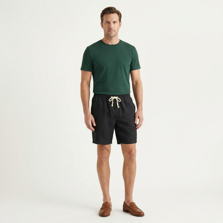 Men linen beach shorts in black worn with green t shirt and loafers