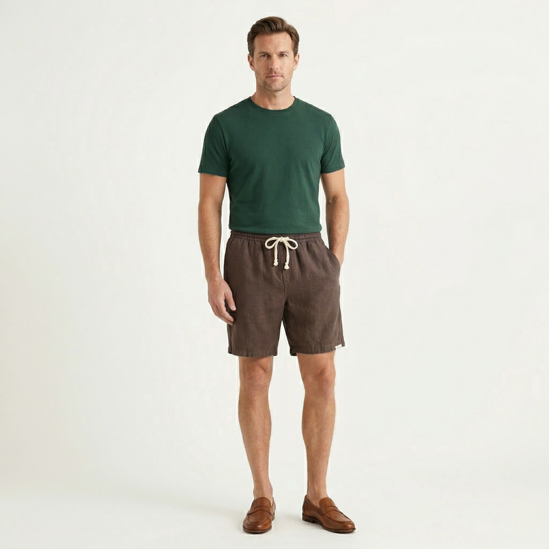 Men brown linen beach shorts worn with green t shirt and loafers, full view