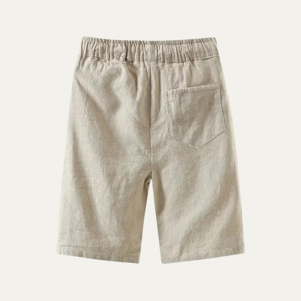 Back view of beige linen knee length shorts with elastic waist and patch pocket