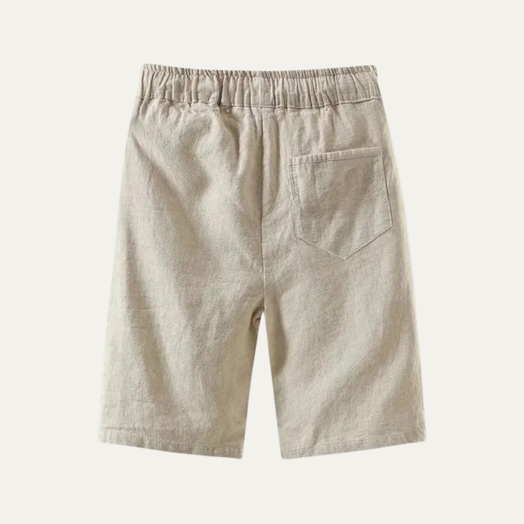Back view of beige linen knee length shorts with elastic waist and patch pocket