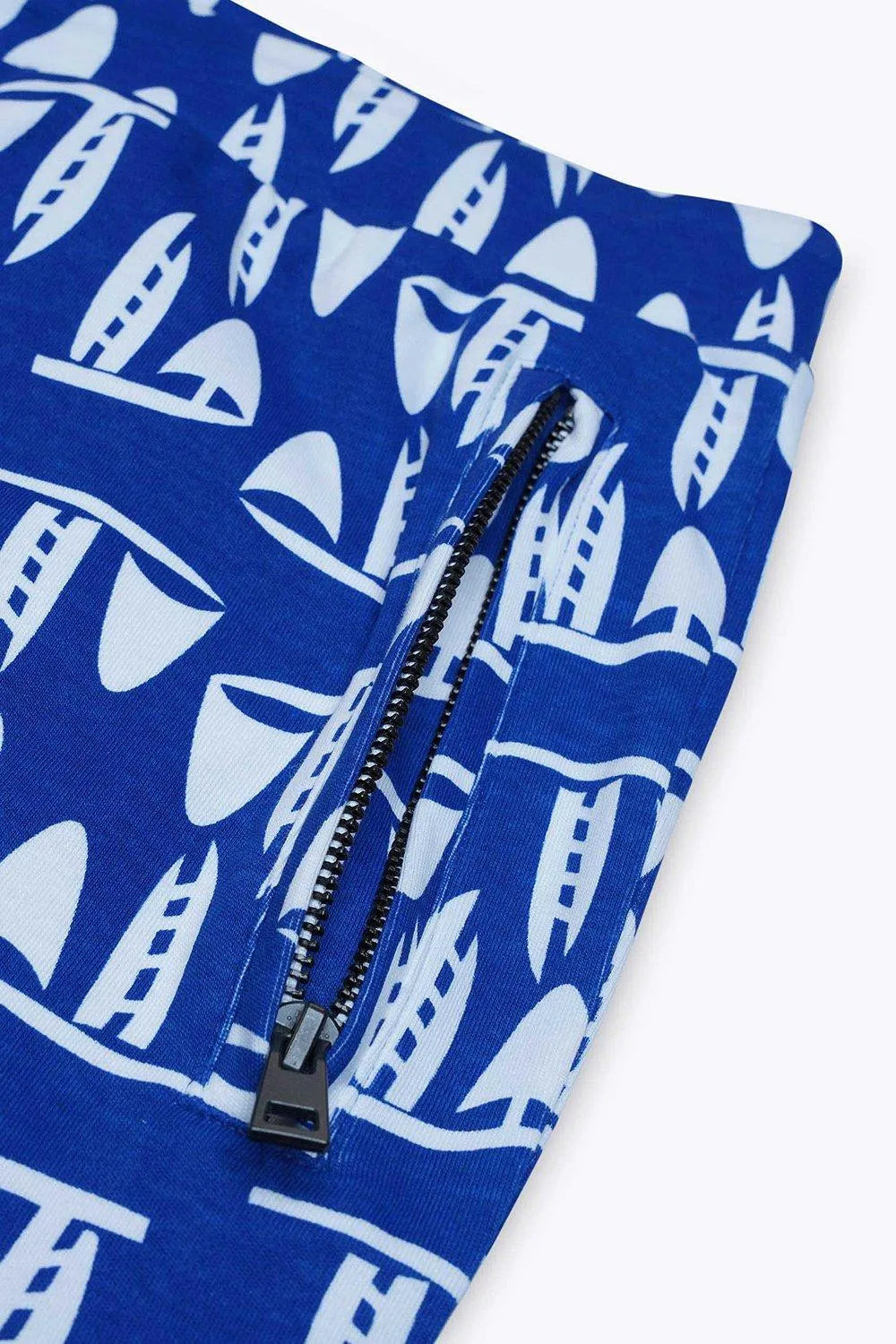 Close-up blue sailboat print mens shorts showing zipper pocket and smooth fabric texture