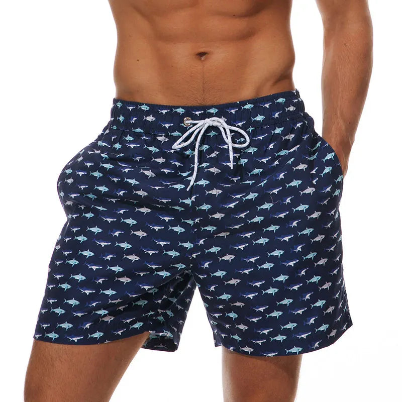 Navy fish print swim shorts for men with pockets and white drawstring waist, front view