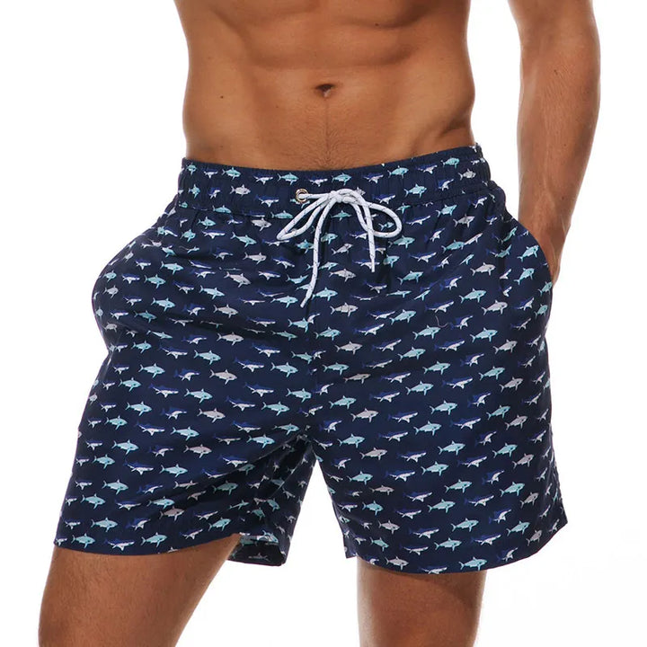 Navy fish print swim shorts for men with pockets and white drawstring waist, front view