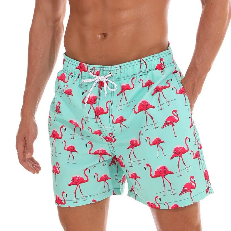 Aqua flamingo print swim shorts with pockets and white drawstring waist, angled front view