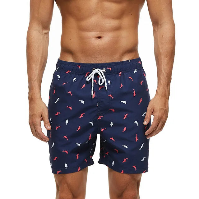 Navy printed swim shorts with shark pattern, side pockets and white drawstring waist