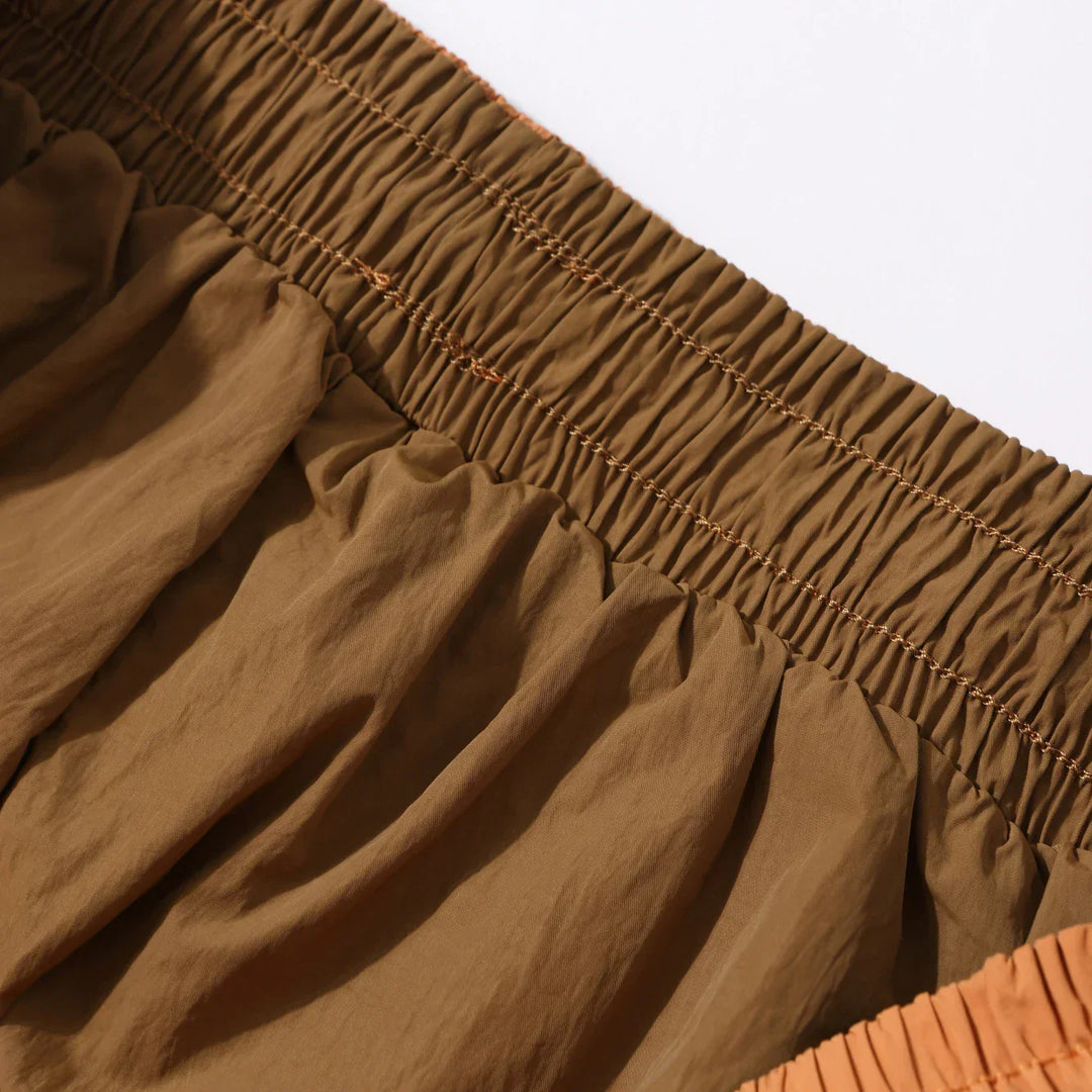 Close-up of brown quick dry casual shorts showing elastic waistband and textured lightweight fabric