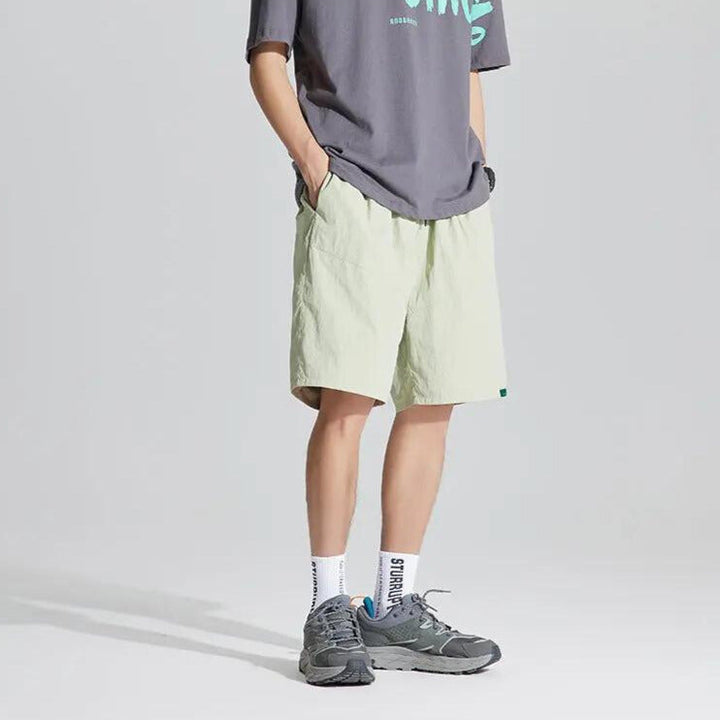 Side view of light green quick dry casual shorts with roomy pockets and loose summer fit