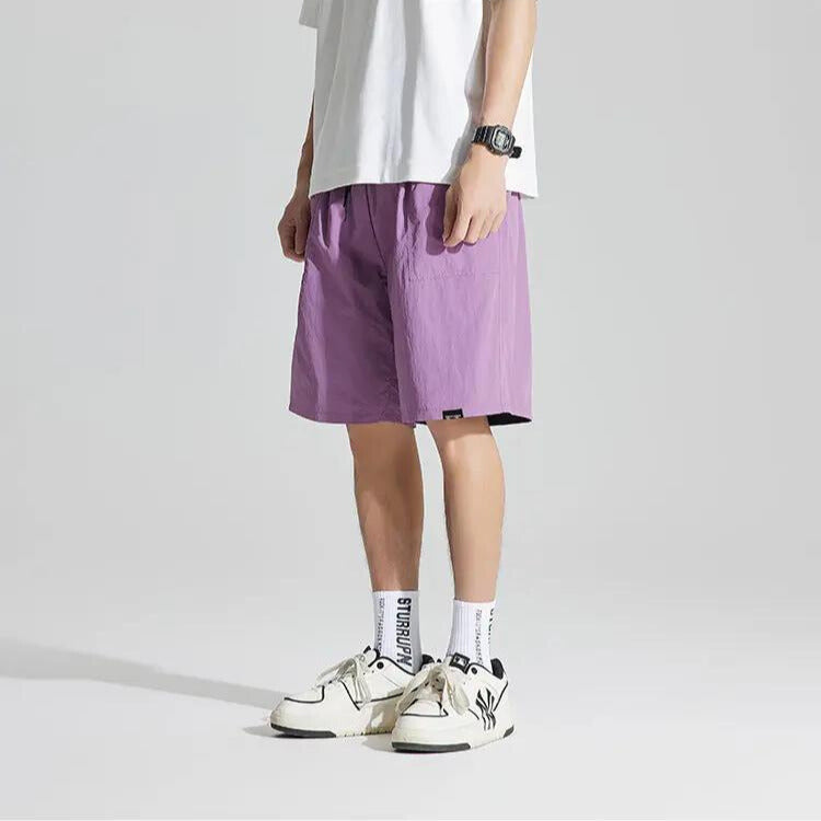 Purple quick dry casual shorts with elastic waist and straight leg cut, shown in angled side view