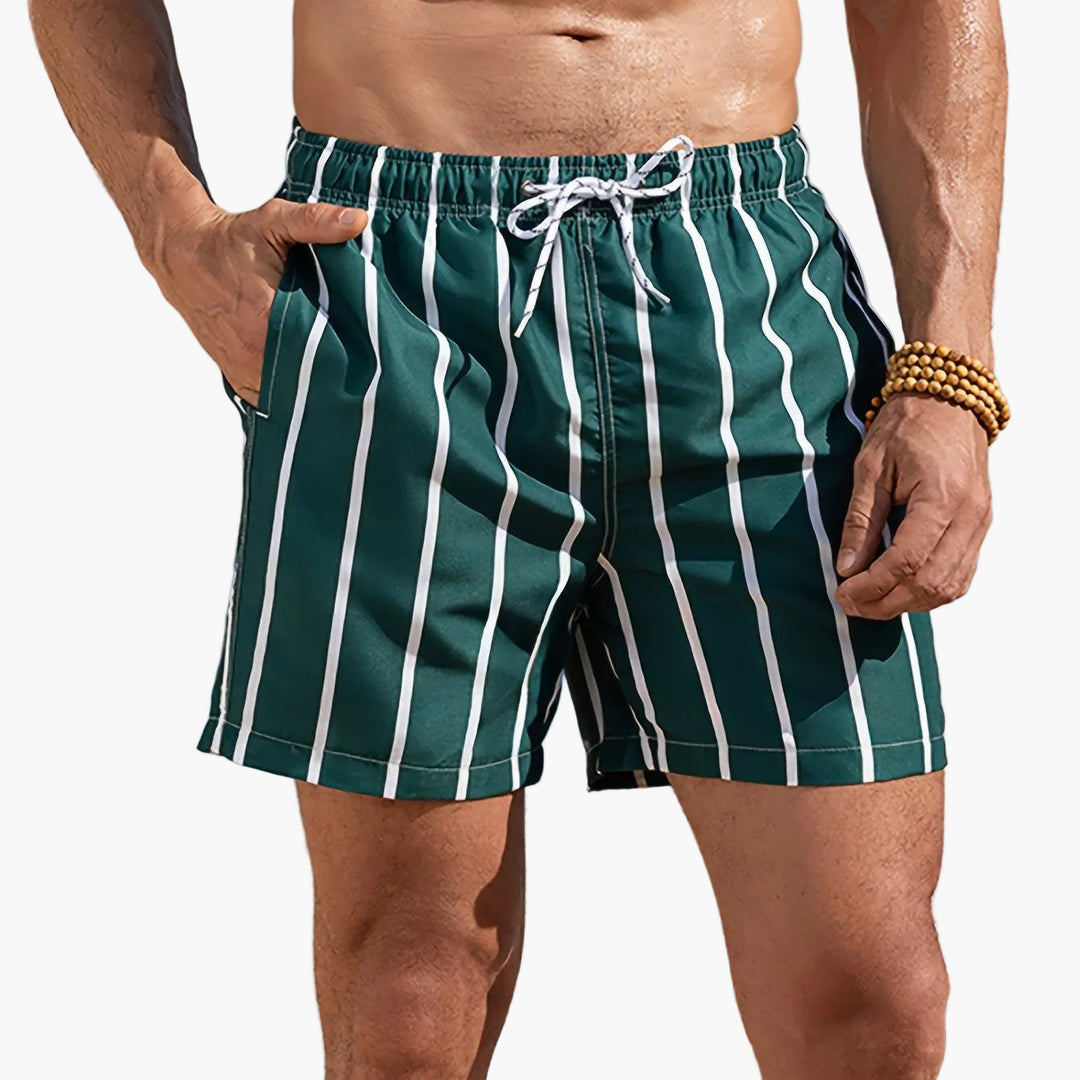 Product view of men striped swim shorts with pockets, dark green and white vertical stripes