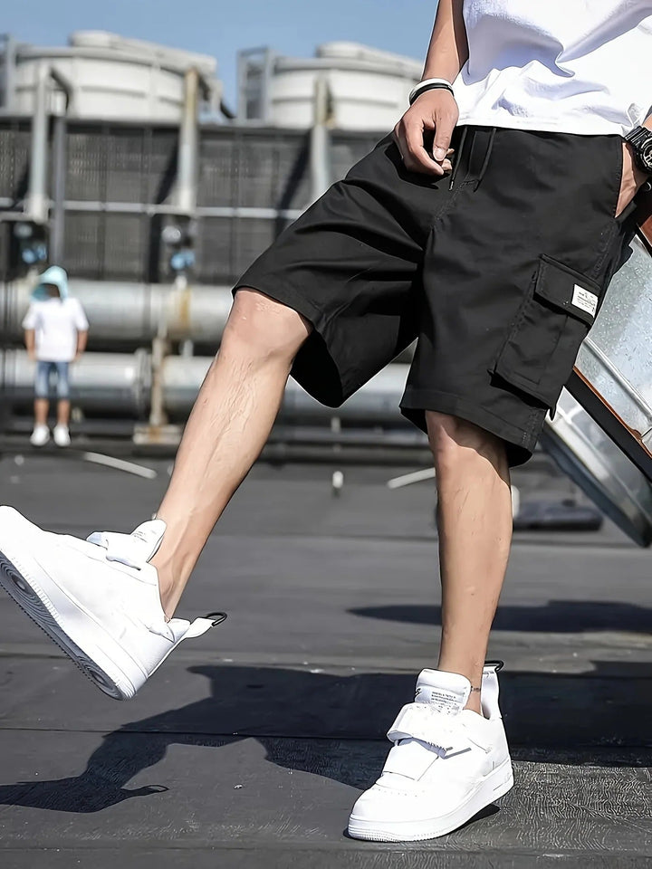Black men summer cargo shorts with pocket detail and loose fit, shown with white sneakers