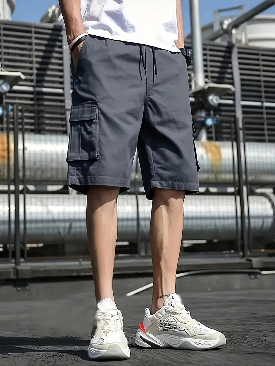 Dark gray men cargo shorts with side pockets and drawstring waist, styled with white sneakers