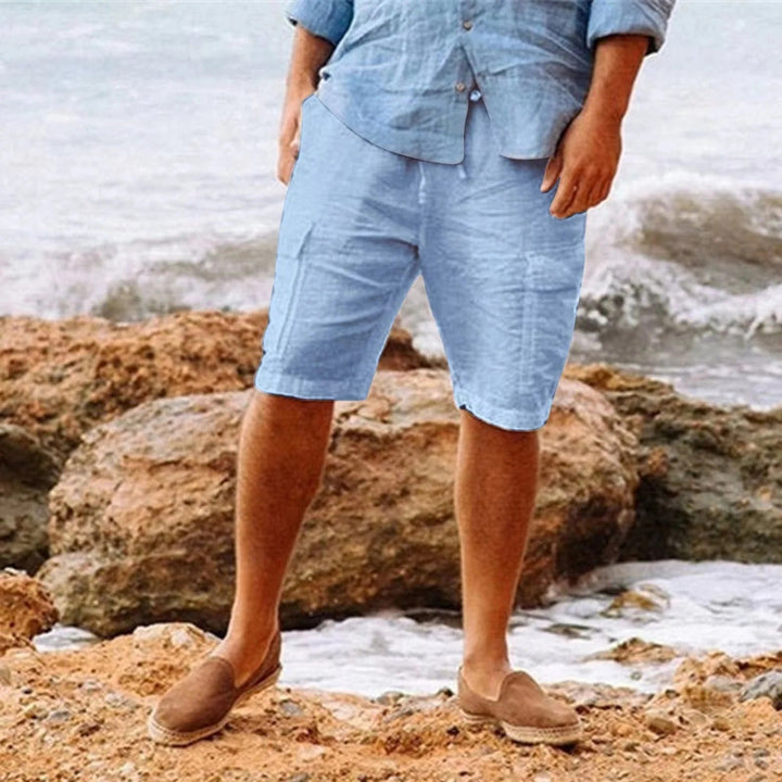 Men's light blue knee length shorts with casual fit, paired with a matching shirt and loafers