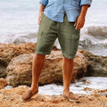 Men's olive green knee length shorts with relaxed fit, shown with a light blue shirt and loafers