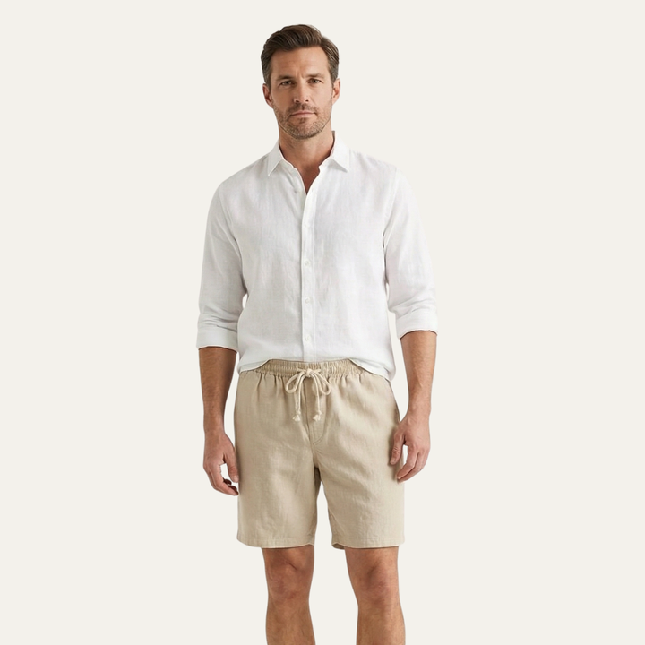 Model wearing beige linen shorts with white button shirt, casual summer shorts for men