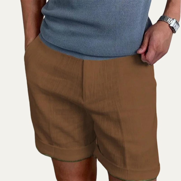 Brown linen shorts for men shown on model, relaxed fit with side pockets and rolled hems