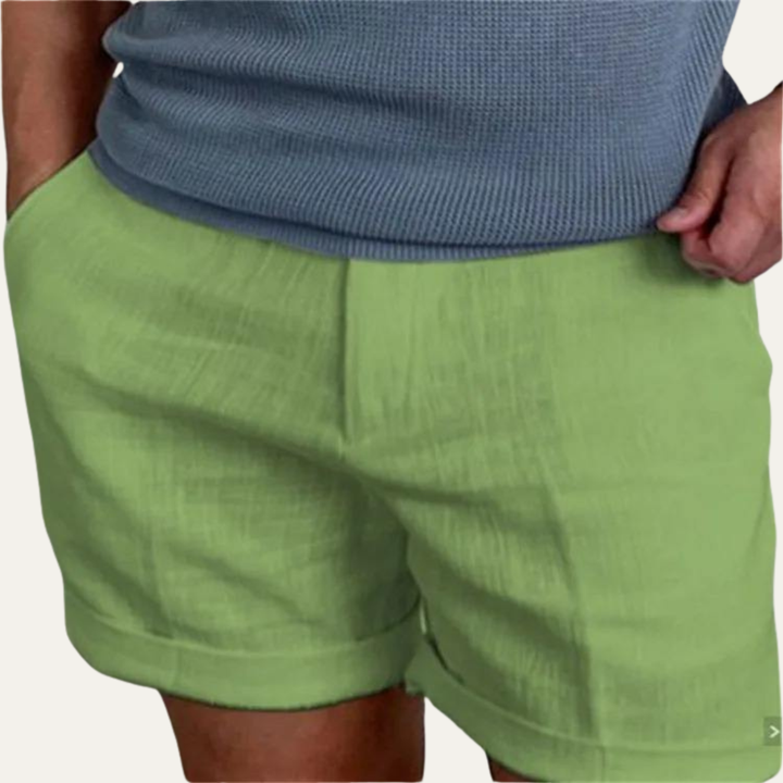 Green summer linen shorts for men on model, relaxed fit with elastic waistband and rolled hems