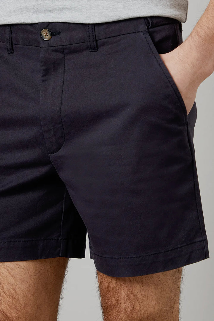 Close-up of navy men tailored shorts waistband with button closure, belt loops, and pocket opening