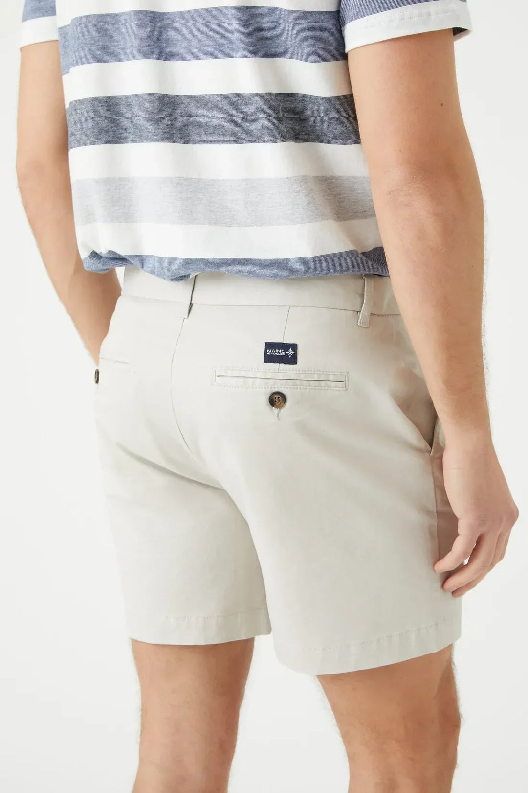 Back detail of light beige tailored shorts for men showing rear welt pocket with button closure