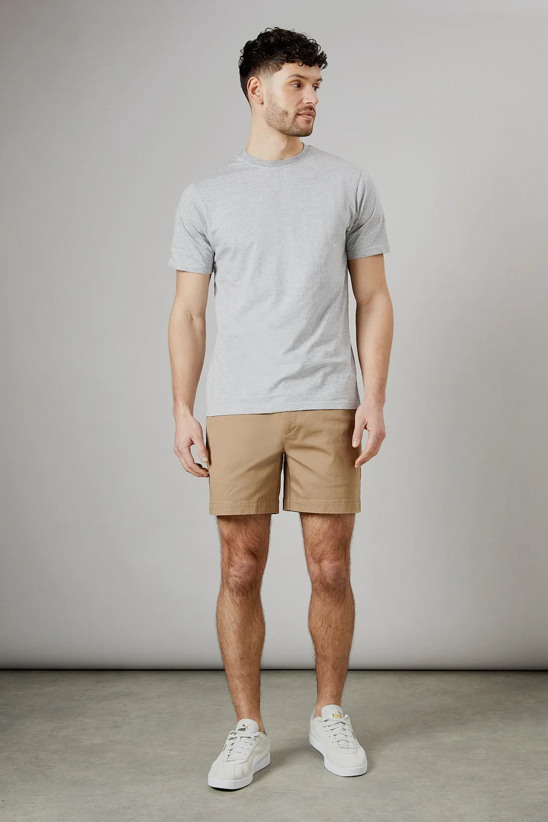Khaki men summer tailored shorts with pockets, front view styled with gray t shirt and sneakers