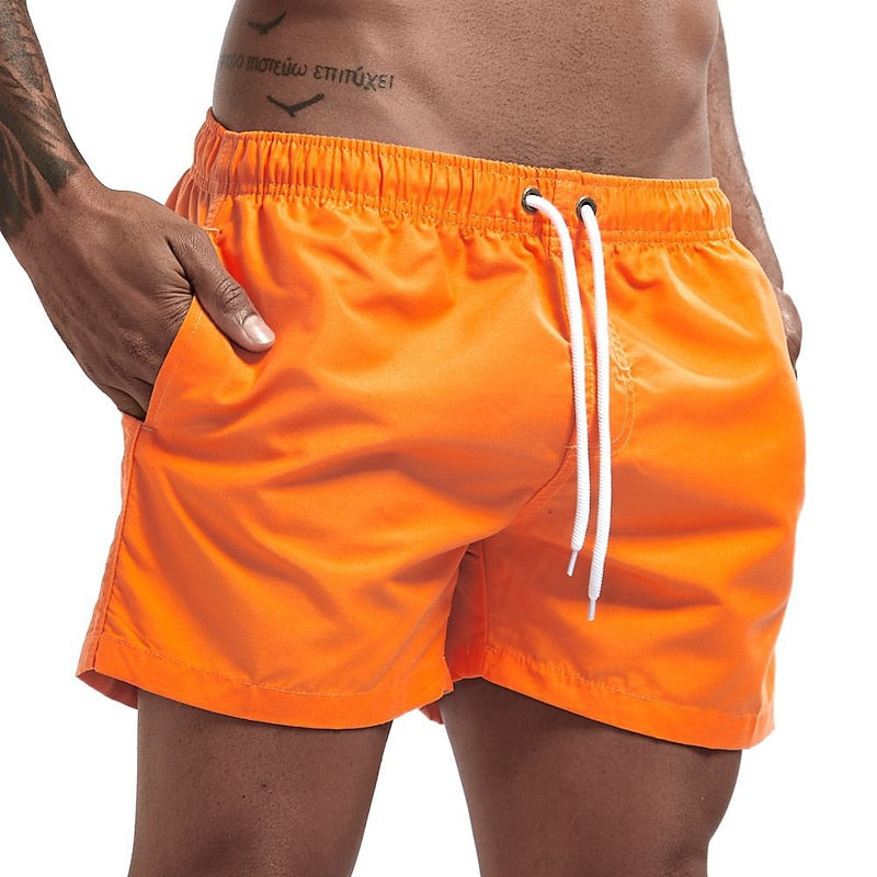 Bright orange men swim shorts with elastic waist, white drawstring, and pocket detail